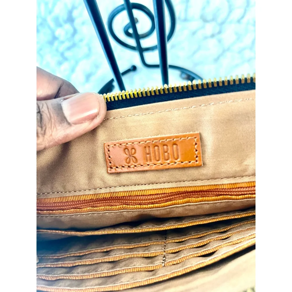 Hobo Wayfare wristlet in black pebbled leather with gold stars